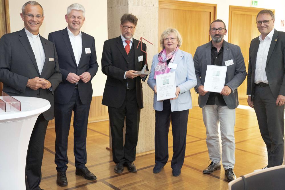 Fünf Personen in Anzügen im Halbkreis stehend